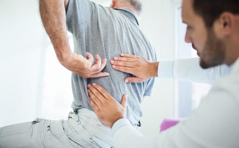 A pain doctor examining a patient’s back pain.