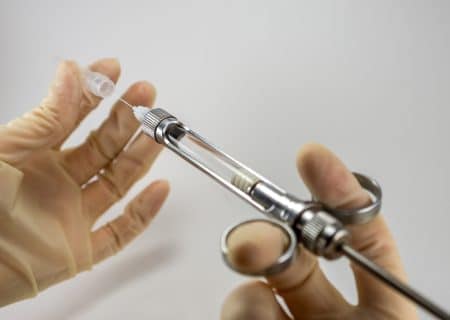 Doctor filling a syringe with trigger point injections.